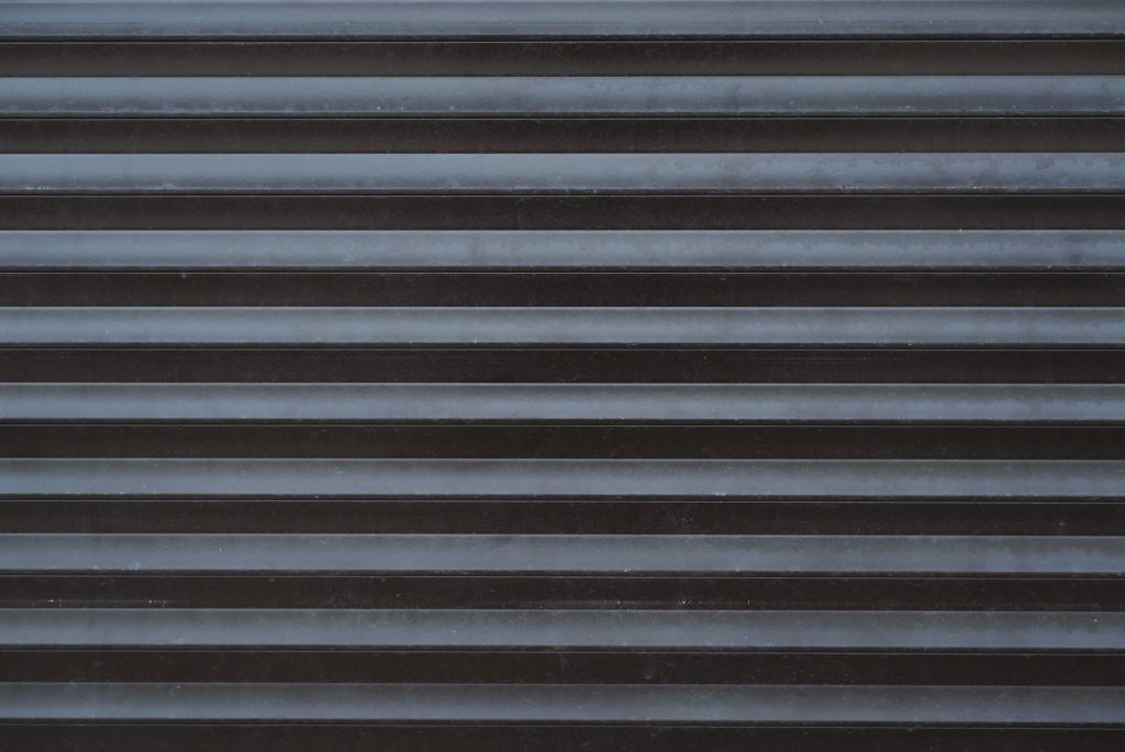 Iron automatic blinds, roller shutters close-up, outside. Textured back